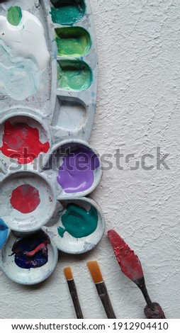 acrylic paint in the palette, brush and palette knife, perfect for background design ideas