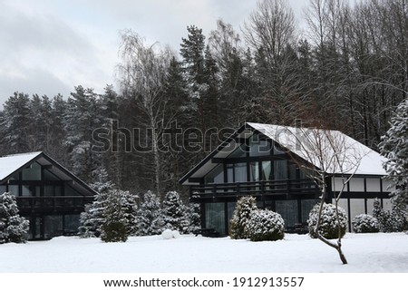 Cottages in winter forest with snow, horizontal picture
