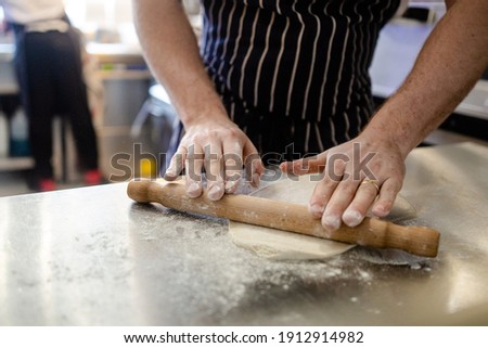 Flatbread being rolled out on a floured surface
