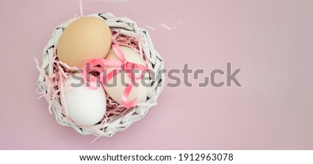 pastel Easter composition, eggs in a decorative nest on a pink background,