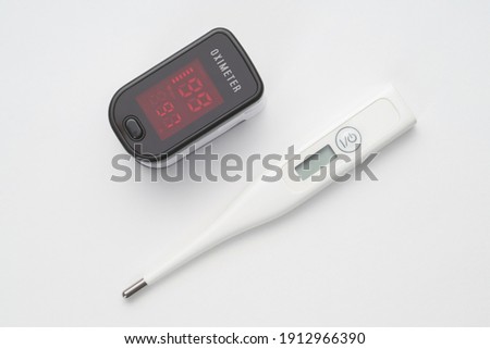 Top view of portable digital fingertip oximeter and thermometer  Royalty-Free Stock Photo #1912966390
