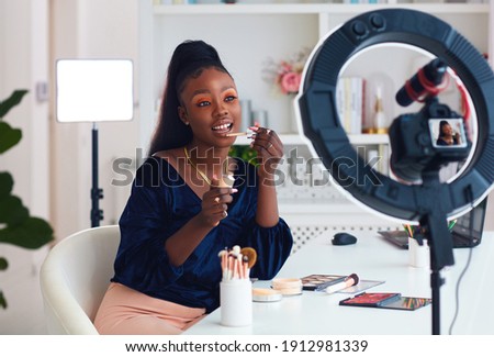 young african american woman streaming a beauty vlog from home, online content creator Royalty-Free Stock Photo #1912981339
