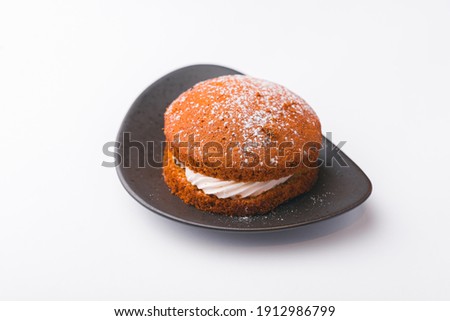 Photo of tasty cake with white cream over white background.
