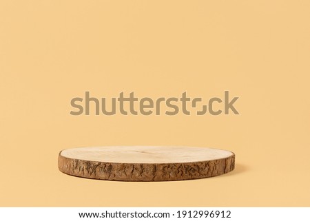Round wooden saw cut cylinder shape for product presentation on a beige background. Round geometric shape of the cylinder. wood slice Royalty-Free Stock Photo #1912996912