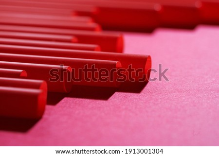 row of red plastic drinking straw on red background           