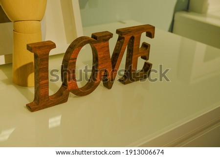 Wooden Love decorations bord on white commode close-up. Wooden word, letter. Home decor. Home interior design. St. Valentine's 