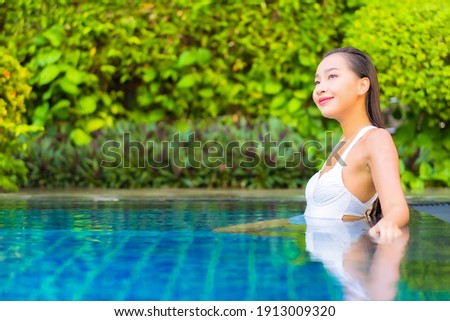 Portrait beautiful young asian woman relax smile enjoy leisure around swimming pool in resort hotel on vacation