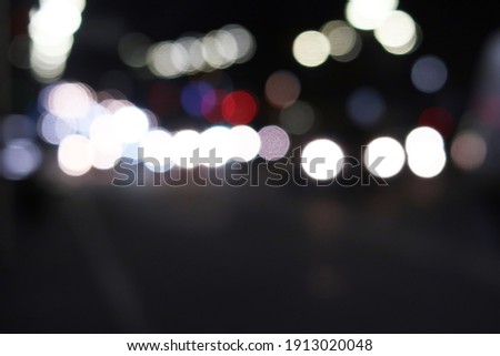 Abstract defocused picture of a dark night street car traffic lights