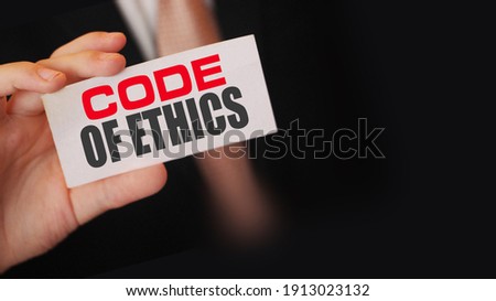Businessman shows a card with text Code of ethics.