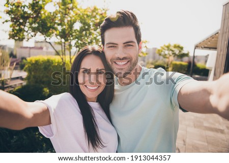 Photo of lovers couple take selfie look camera toothy shiny smile wear casual clothes in garden park outdoors