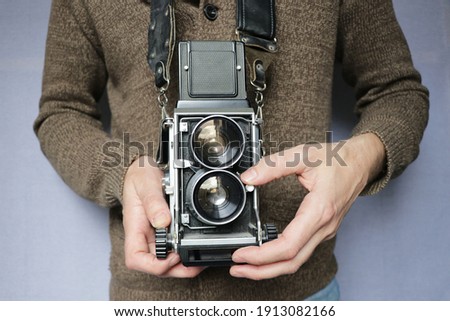 hands holding a vintage medium format camera