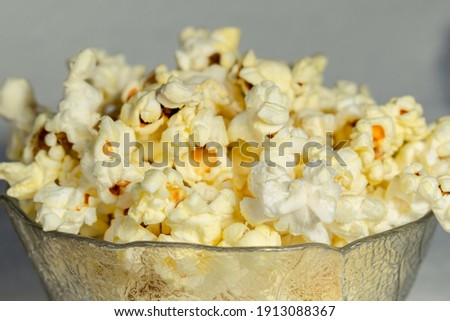 Salted popcorn on a light background. Close-up.