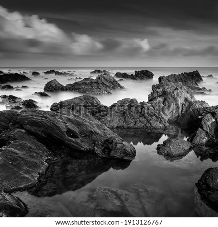 Long exposure seascape in black and white. A slow shutter speed was used to see the movement ( Soft focus due to long exposure shot ) soft and grain effect.