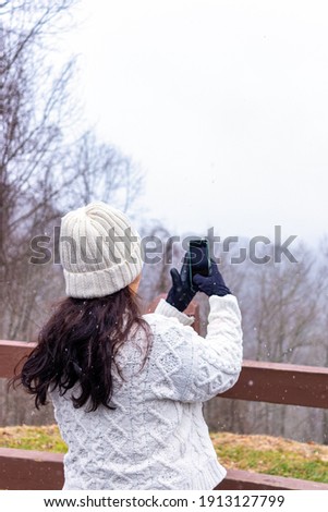 Young woman taking landscape photos with her smartphone