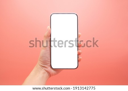 Hand woman holding mobile smartphone with blank screen isolated on pink background, close-up hand touching phone isolated on pink,mock-up smartphone blank screen easy adjustment . Royalty-Free Stock Photo #1913142775