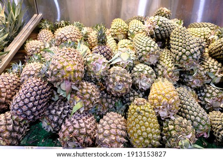 Pictures of pineapples sold in a market.