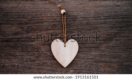 Valentine's Day background. Brown natural boards in grunge style with one wooden decorative hearts. Top view. Surface of table to shoot flat lay. Concept love, romantic relation. Banner