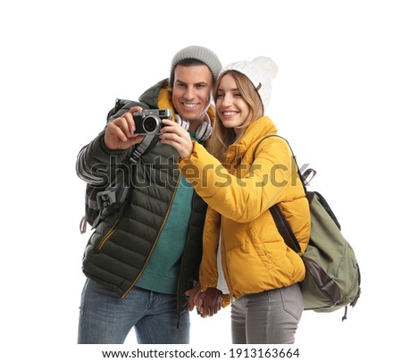 Couple with camera on white background. Winter travel