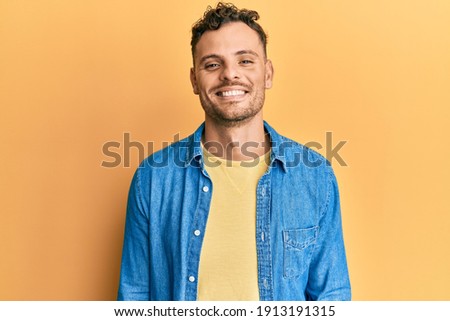 Young hispanic man wearing casual clothes with a happy and cool smile on face. lucky person. 