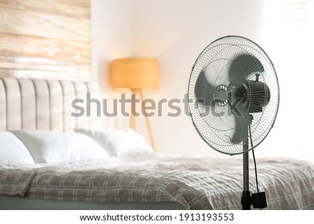 Modern electric fan in bedroom. Space for text Royalty-Free Stock Photo #1913193553