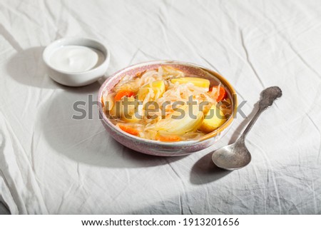 Vegetarian sour soup with sauerkraut on gray background. Comfort healthy food