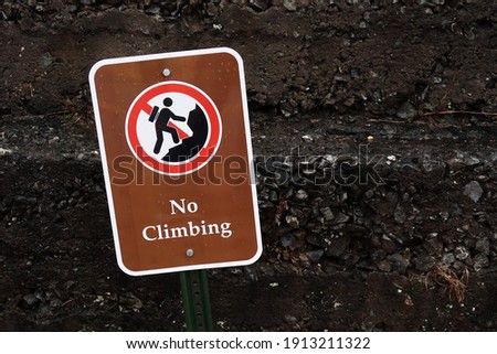 Off centered sign that says, NO CLIMBING.                                
