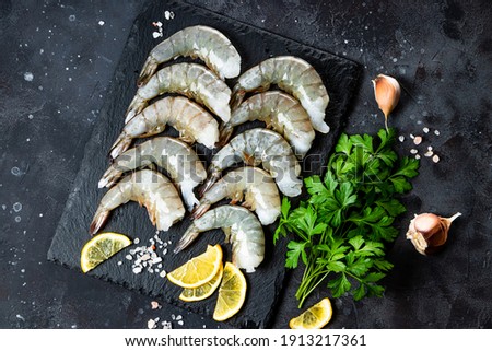  Raw shrimps with garlic and lemon on the dark gray background top view