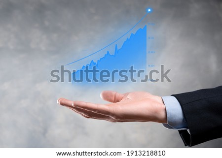 Businessman holding graph growth and increase of chart positive indicators in his business.Investment up concept.analyzing sales data and economic,strategy and planning, Digital and stock market.
