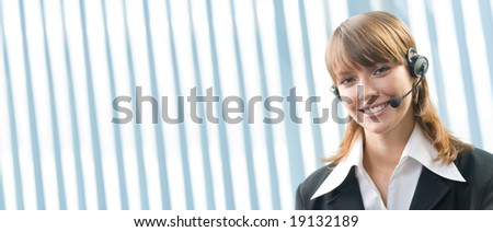 Young cheerful businesswoman with headset garniture at office. Banner with lots of copyspace.