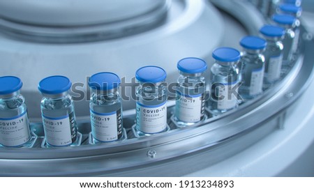SARS-COV-2 COVID-19 Coronavirus Vaccine Mass Production in Laboratory, Bottles with Branded Labels Move on Pharmaceutical Conveyor Belt in Research Lab. Medicine Against SARS-CoV-2. Royalty-Free Stock Photo #1913234893