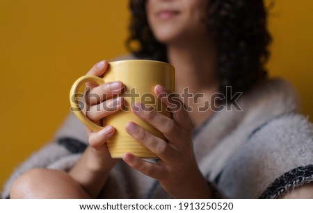 
woman drinking from yellow cup