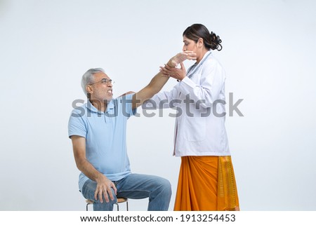 Physical therapist helping old man.
