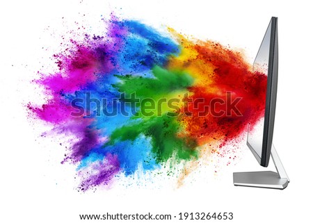 modern black silver pc computer monitor with colorful rainbow spray holi powder cloud explosion through flat screen isolated on white background. multimedia abstract industry art streaming concept