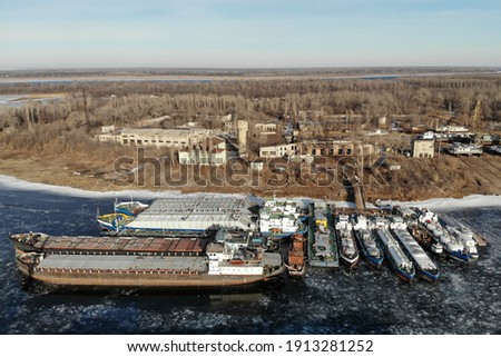 Wintering ships on a frozen river. There are many ships at the pier. Volgograd. Russia.