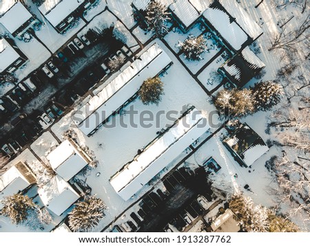 Drone Aerial Photo of Snowy Apartments Houses Townhomes after snowstorm. Birds eye view of neighborhood