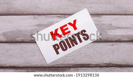 On a wooden background, there is a white card with red text KEY POINTS