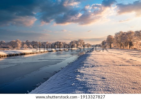 Sunrise in Wiesmoor, Eastfrisa on a cold winter morning with snow and a colorful sunrise. Royalty-Free Stock Photo #1913327827