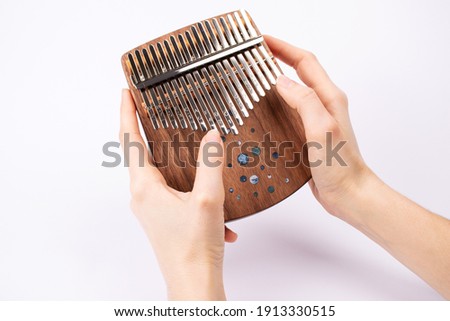 Woman playing for kalimba close up. Kalimba or Mbira is an African musical instrument in hands on white background. Music concept