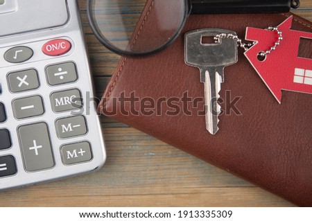Property assessment. Miniature house with key,  magnifier and calculator. Real estate concept