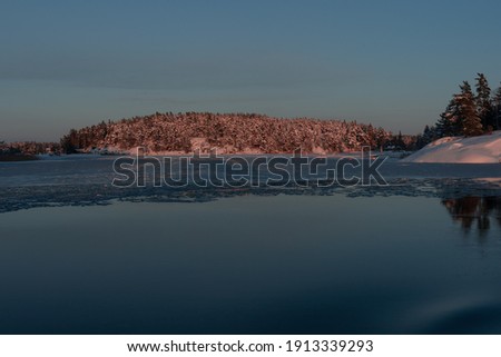 Dawn over the frozen sea, between the islands Scandinavian nature. Finland.