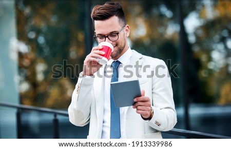 I have a vision. Businessman using tablet and enjoying in coffee break in front of the the corporation. Business, lifestyle concept