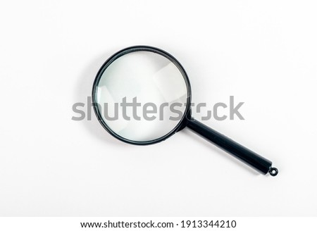 Magnifying glass or lens on white, top view. Royalty-Free Stock Photo #1913344210