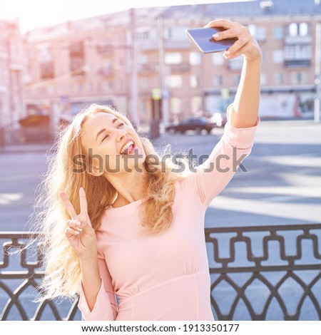 Young woman doing self portrait outside. City vacation portrait. Blogger selfie video. travel local. Alone tourist. Happy emotion. Smiling female person. Lifestyle action. Posing