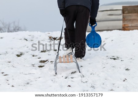 A man pulls a sled up the hill. Winter joys in nature