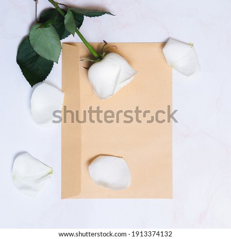 
the rose lies on a paper envelope as a background. valentine's day celebration and eighth march concept