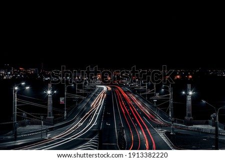 Mysterious night road captured with long exposure. The red and white car headlights evoke a sense of imagination. Perfect for use in website design or advertising banners to grab attention to a produc