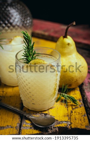 glass of pear juice and rosemary on a wooden board. Still life photography. dark style. vertical photography for social media