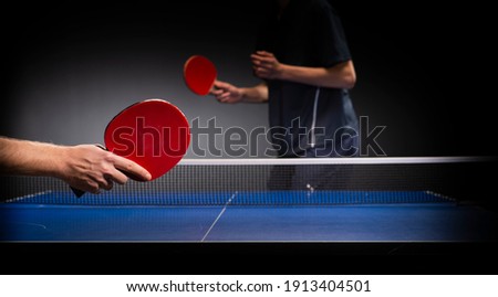 Two young boys playing table tennis, focus on racquet  Royalty-Free Stock Photo #1913404501