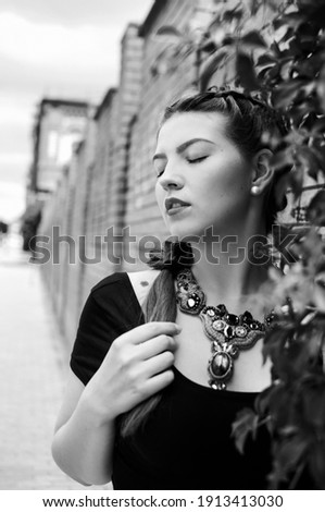 Black and white photographs of a beautiful girl walking around the city. She is happy and full of strength, youth, a successful lady, an attractive personality.