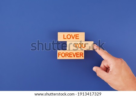 a man puts wooden cubes into the inscription love you forever